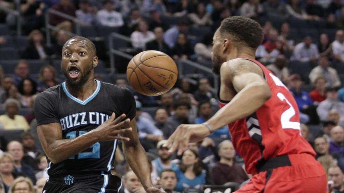 Charlotte Hornets' Kemba Walker (left) finds a teammate with a first-half pass in the Hornets blowout of the Toronto Raptors.