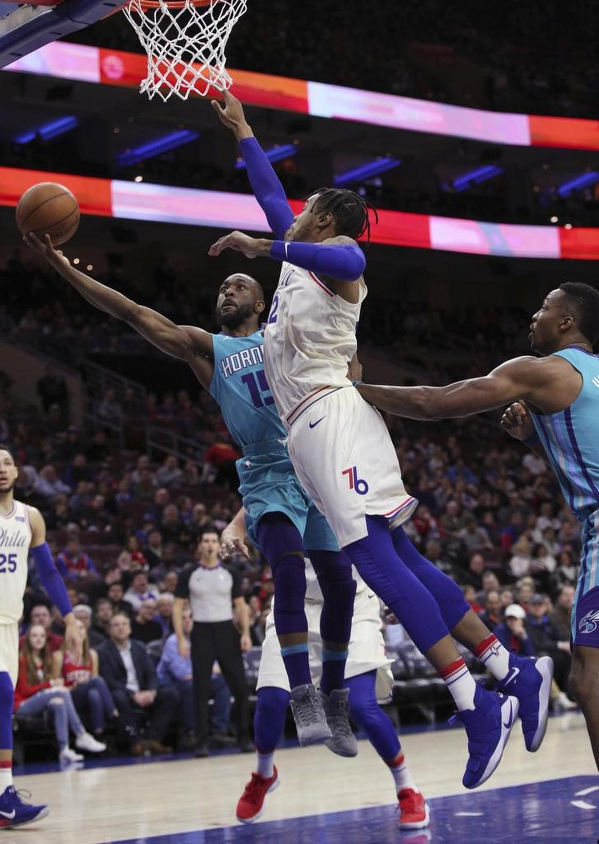Charlotte Hornets guard Kemba Walker shoots as Philadelphia 76ers’ Richaun Holmes defends during the first half of Friday’s game at the Wells Fargo Center in Philadelphia. Walker scored 31 points in the loss.