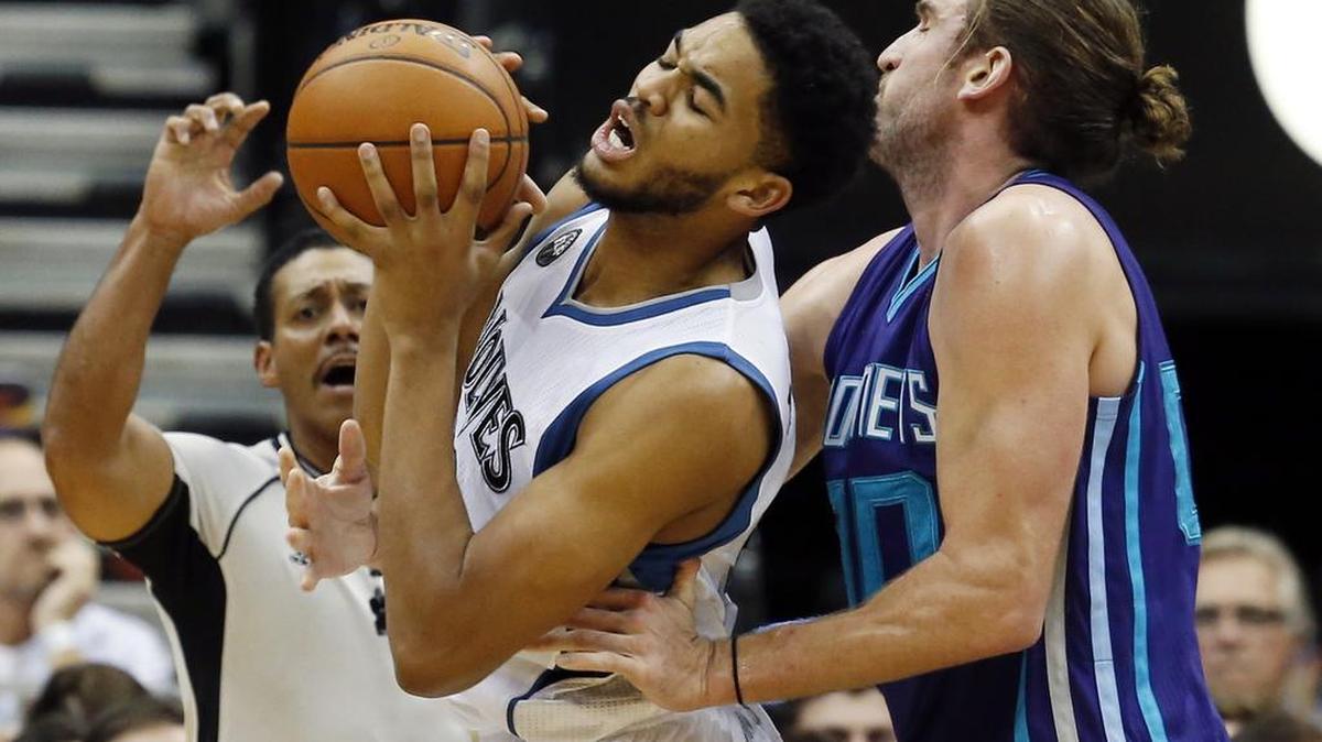 Minnesota Timberwolves’ Karl-Anthony Towns, left, tries to get a hand on the ball as Charlotte Hornets’ Spencer Hawes reaches in during the second half of an NBA basketball game, Tuesday, Nov. 10, 2015, in Minneapolis. The Hornets won 104-95.