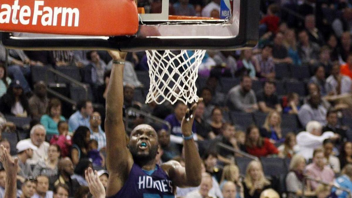 Charlotte Hornets' Al Jefferson (25) scores in the paint against Philadelphia 76ers' T.J. McConnell (12) and Robert Covington (33) in the second half of Friday’s game in Charlotte. The Hornets won 113-88.