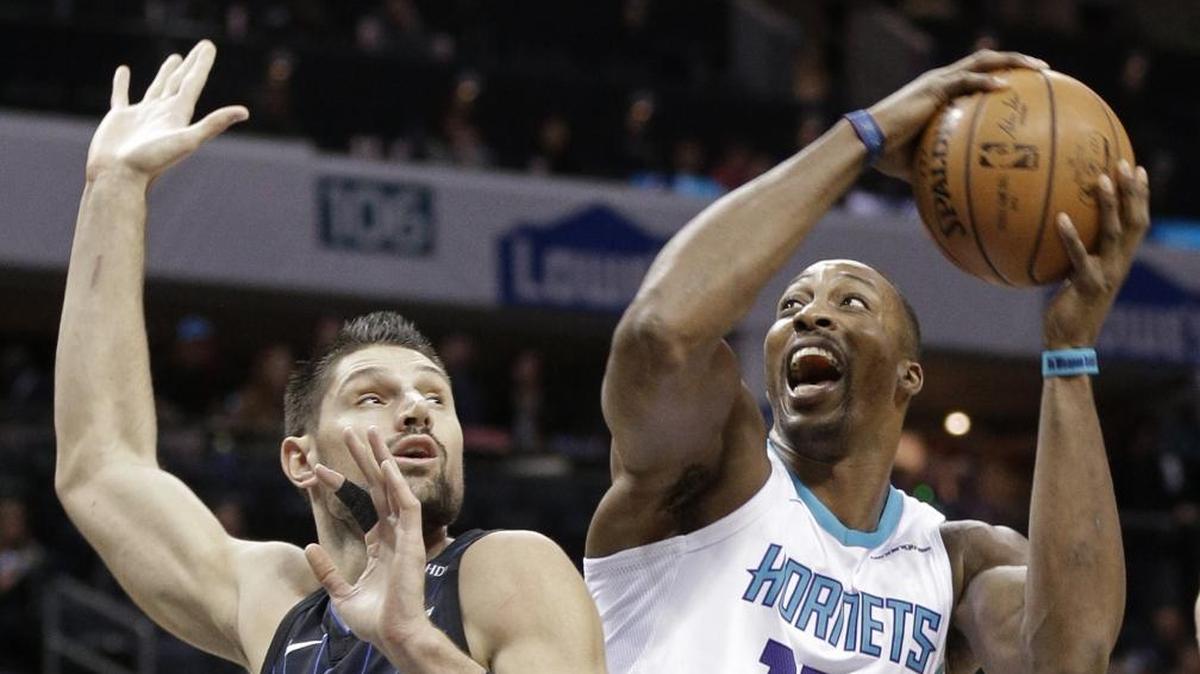 Charlotte Hornets center Dwight Howard (12) drives against Orlando Magic’s Nikola Vucevic (9) during the first half on Monday in Charlotte.