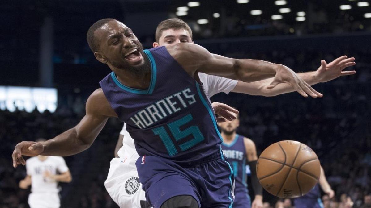 Charlotte Hornets guard Kemba Walker (15) is fouled by Brooklyn Nets guard Joe Harris during the first half of Friday’s NBA game, in New York.