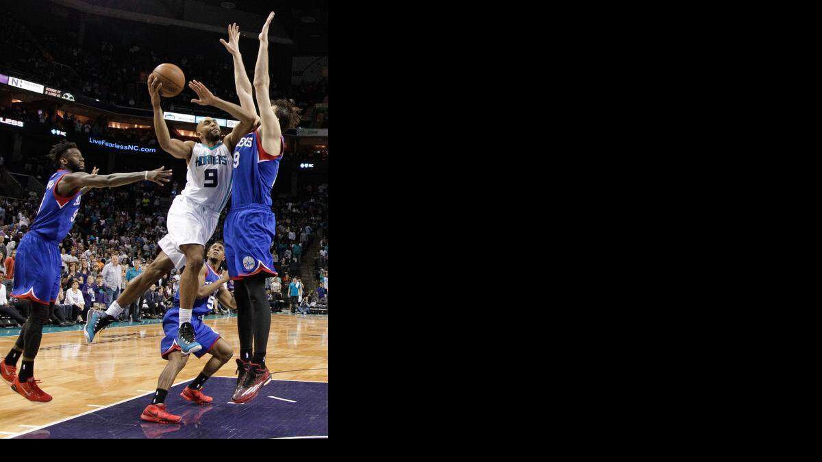
Charlotte Hornets' Gerald Henderson, center, drives against Philadelphia 76ers' Furkan Aldemir, right, and JaKarr Sampson, left, for the go-ahead and eventual game-winning basket during the second half of an NBA basketball game in Charlotte, Saturday, April 4, 2015. The Hornets won 92-91.
