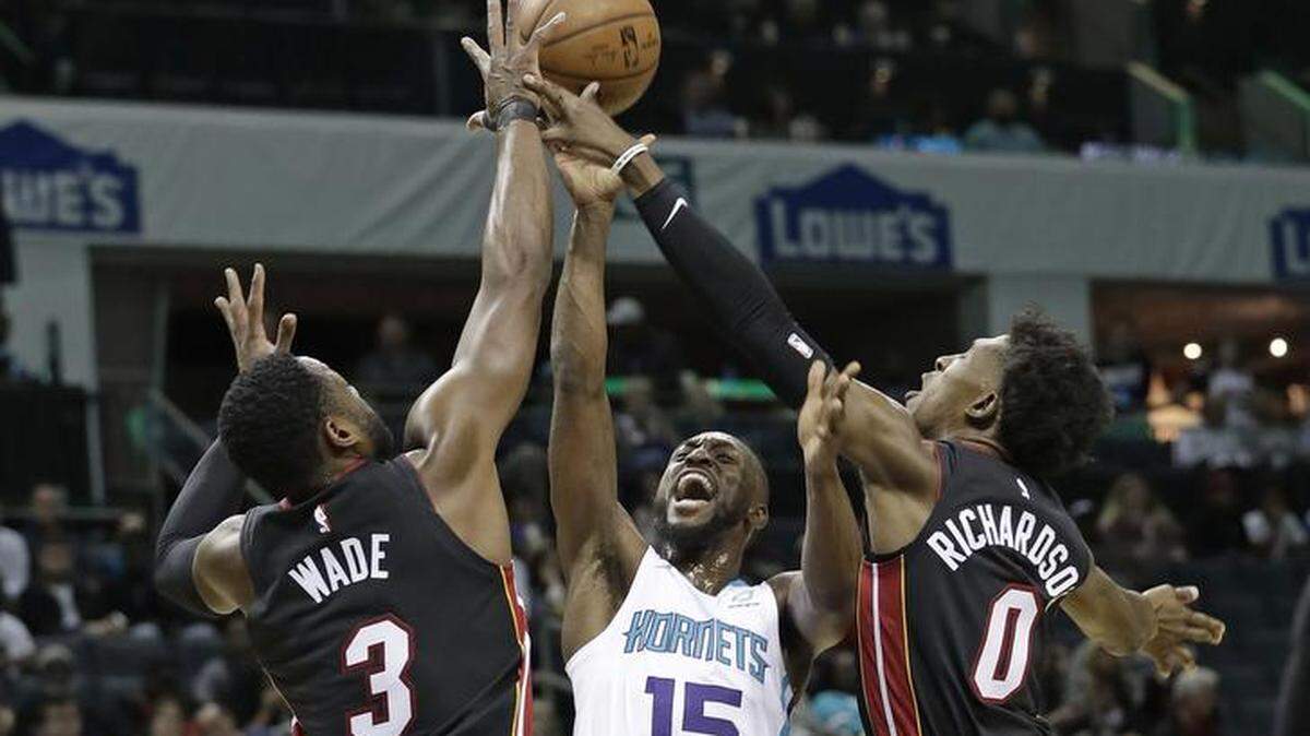 Charlotte Hornets guard Kemba Walker, center, tries to shoot over the Miami Heat’s Dwyane Wade (3) and Josh Richardson (0) in the first half of Tuesday’s NBA game at the Spectrum Center.