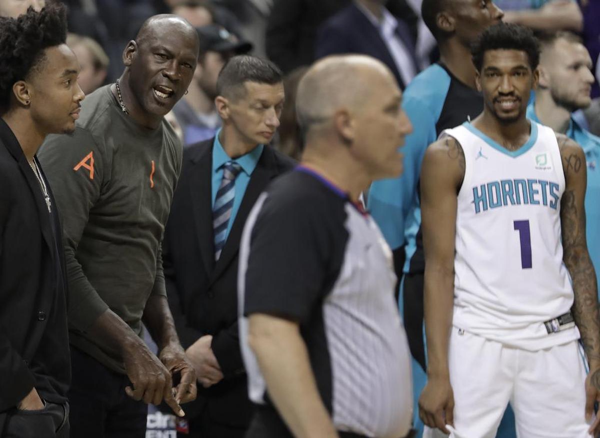 Charlotte Hornets owner Michael Jordan, left, angry over a technical foul called against his team, shouts at a referee in the final seconds of Wednesday’s NBA against the Detroit Pistons. Hornets guard Malik Monk, right, looks on.