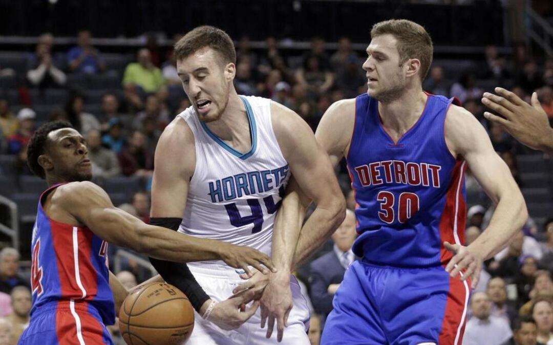 Charlotte Hornets' Frank Kaminsky III (44) is fouled as he drives between Detroit Pistons Jon Leuer (30) and Ish Smith (14).