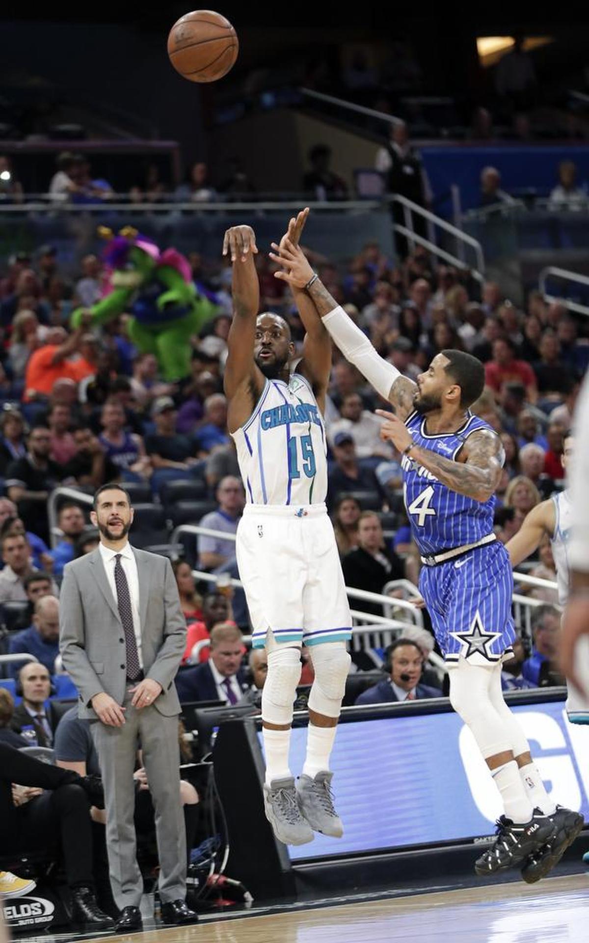 Charlotte Hornets guard Kemba Walker (15) launches a 3-pointer over the Orlando Magic’s D.J. Augustin in the second half of Friday’s game in Orlando, Fla. Charlotte won 120-88 and Walker tied an NBA record for 3-pointers.
