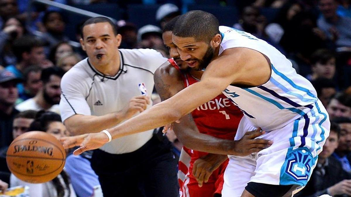 Charlotte Hornets guard Nicolas Batum, right, chases after a loose ball with Houston Rockets forward Trevor Ariza in Thursday’s game. The Rockets defeated the Hornets 107-95.