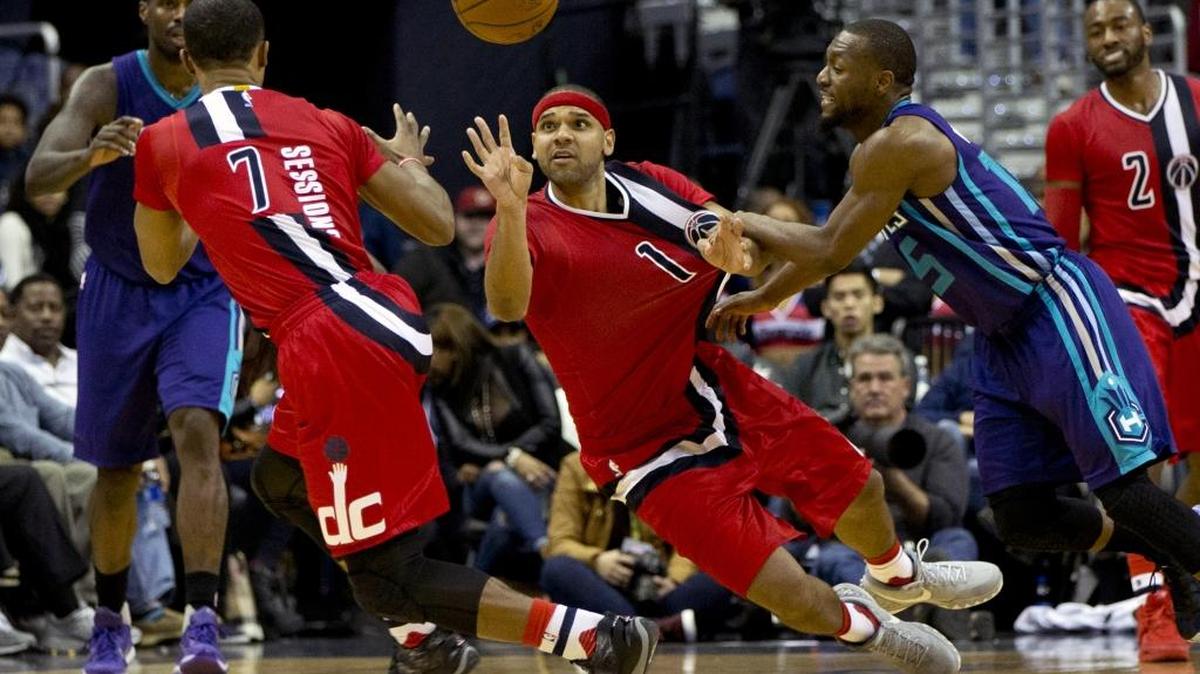 Washington Wizards forward Jared Dudley (1) passes the ball to guard Ramon Sessions (7) while guarded by Charlotte Hornets guard Kemba Walker (15) on Saturday. The Wizards won 109-101.