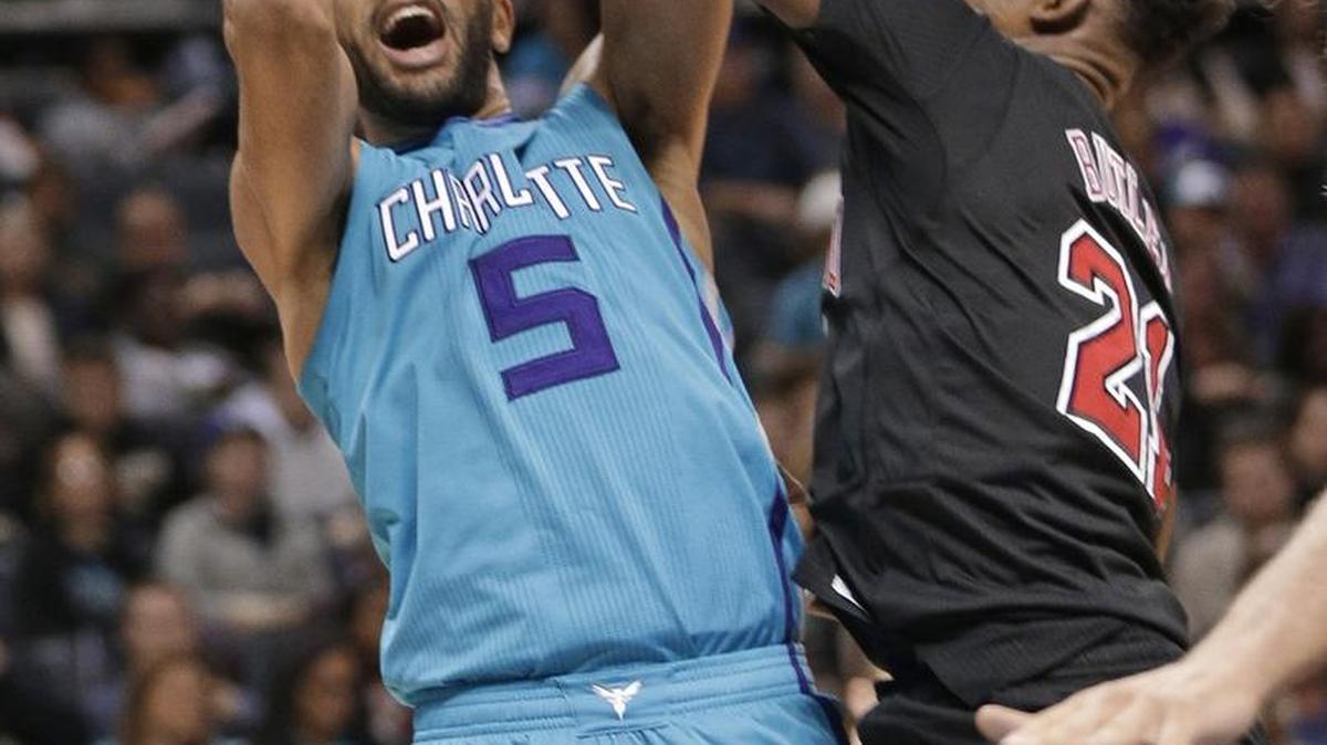 Charlotte’s Nic Batum tries to shoot as Chicago’s Jimmy Butler defends during the second half of Friday night’s game at the Spectrum Center in Charlotte. Batum had a triple-double and the Hornets won 103-91.