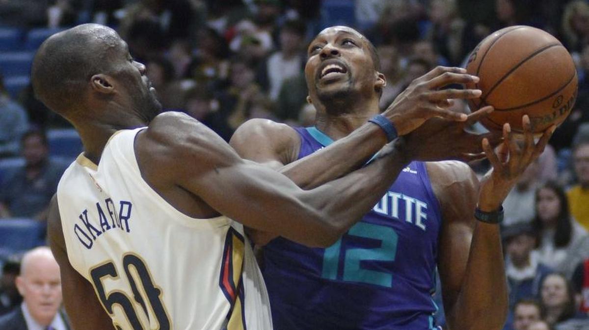Charlotte Hornets center Dwight Howard (right) and the New Orleans Pelicans’ Emeka Okafor fight for a loose ball in the first half of Tuesday night’s game in New Orleans.