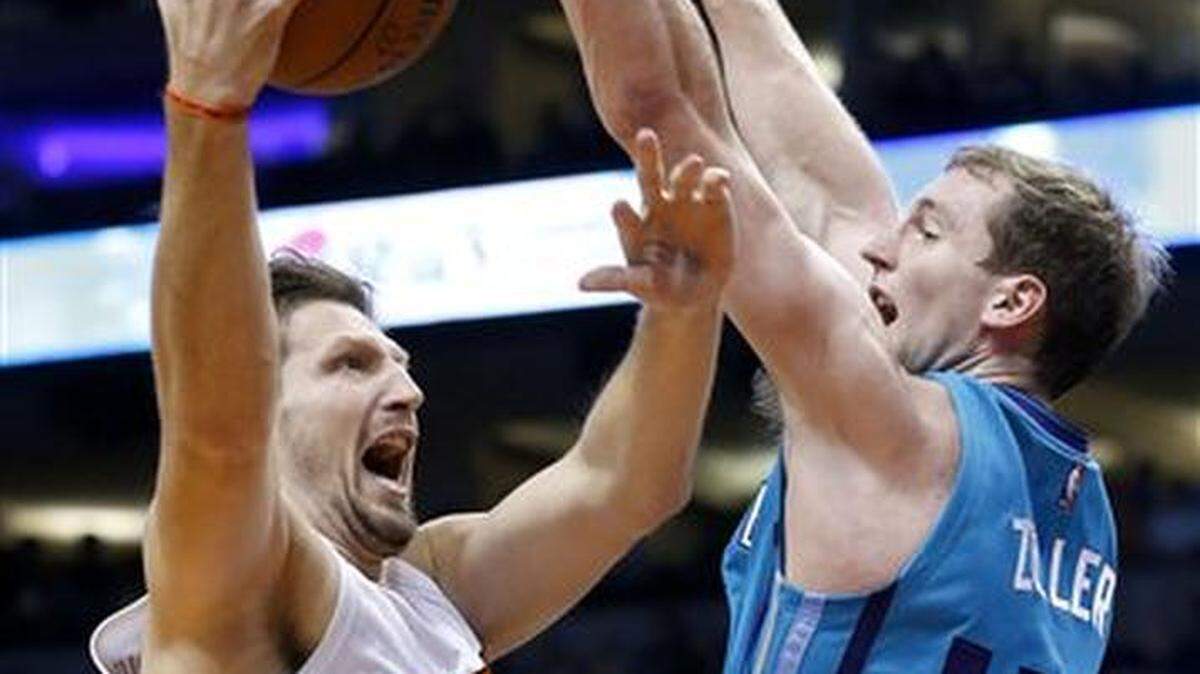 El bosnio Mirza Teletovic, de los Suns de Phoenix, dispara junto a Cody Zeller, de los Hornets de Charlotte, en el duelo realizado el miércoles 6 de enero de 2016