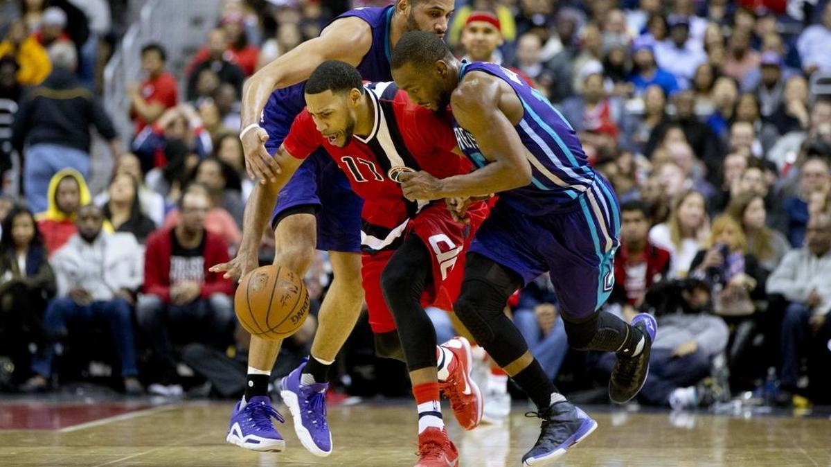 Charlotte Hornets guard Nicolas Batum (5), left, and guard Kemba Walker (15), pursue Washington Wizards guard Garrett Temple (17), after a stray ball in the fourth quarter of Saturday’s game. The Wizards won 109-101.