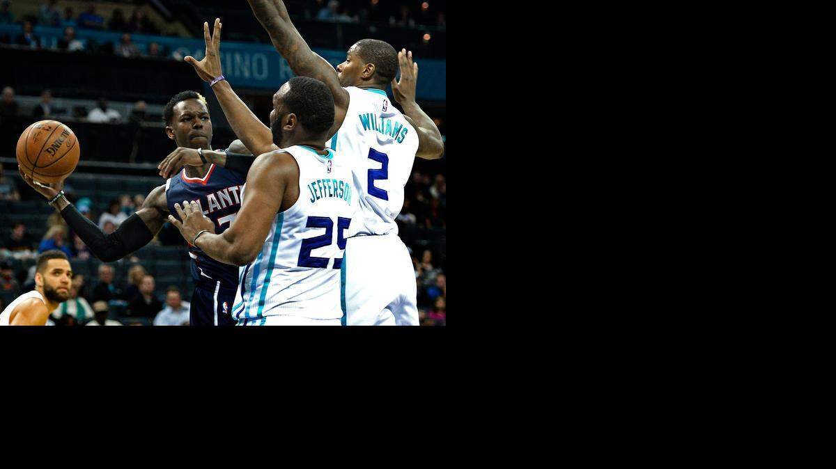 
Atlanta Hawks Dennis Schroder, left, looks to pass to a teammate as Charlotte Hornets Al Jefferson, center and Marvin Williams, right, apply defensive pressure at Time Warner Cable Arena in Charlotte, Saturday, March 28, 2015.

