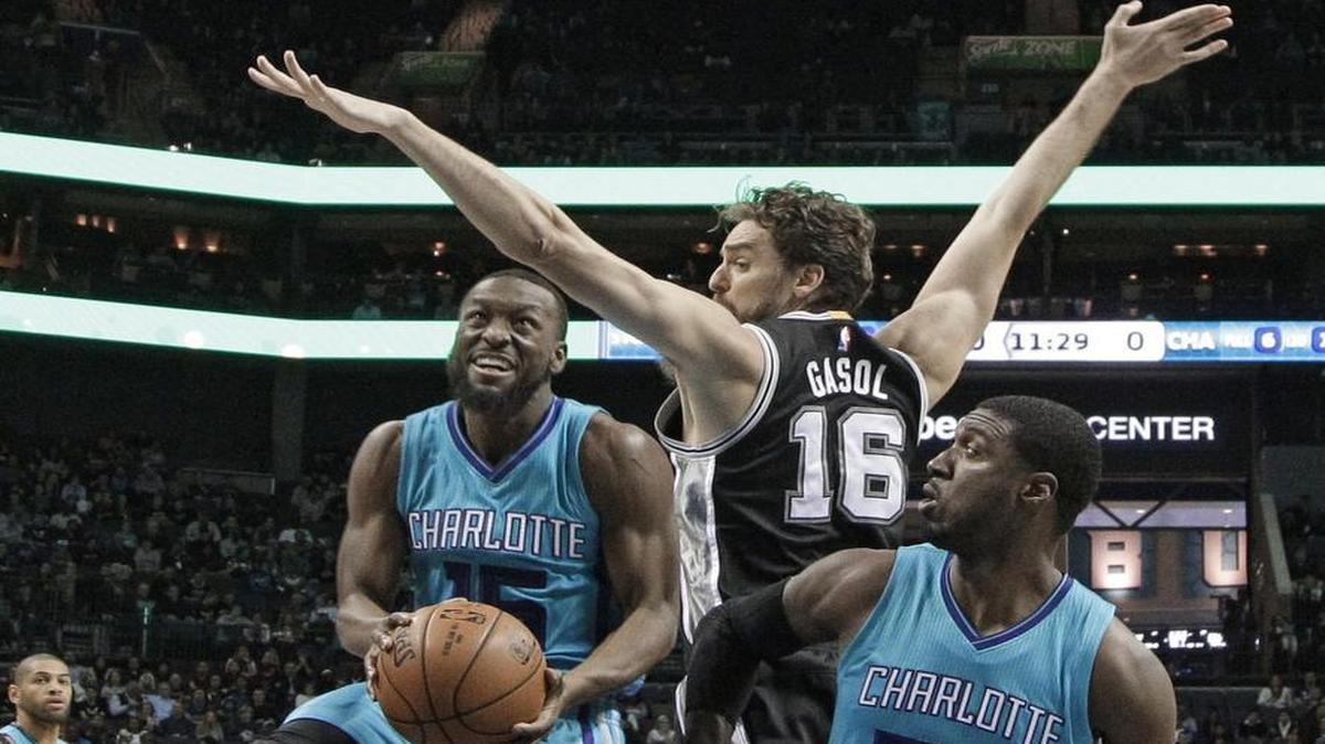Charlotte Hornets' Kemba Walker (15) drives past San Antonio Spurs' Pau Gasol (16) Friday at Spectrum Center.