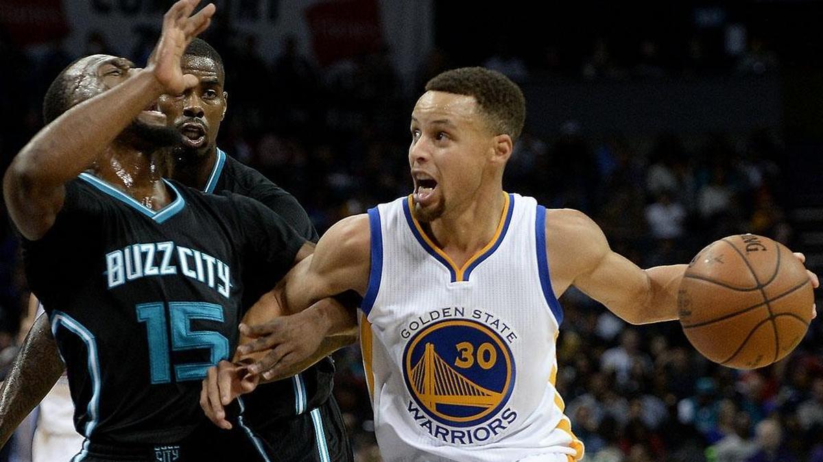 Golden State Warriors guard Stephen Curry, right, drives to the basket as Charlotte Hornets guard Kemba Walker, left, applies defensive pressure during third quarter action at Time Warner Cable Arena in Charlotte on Wednesday.