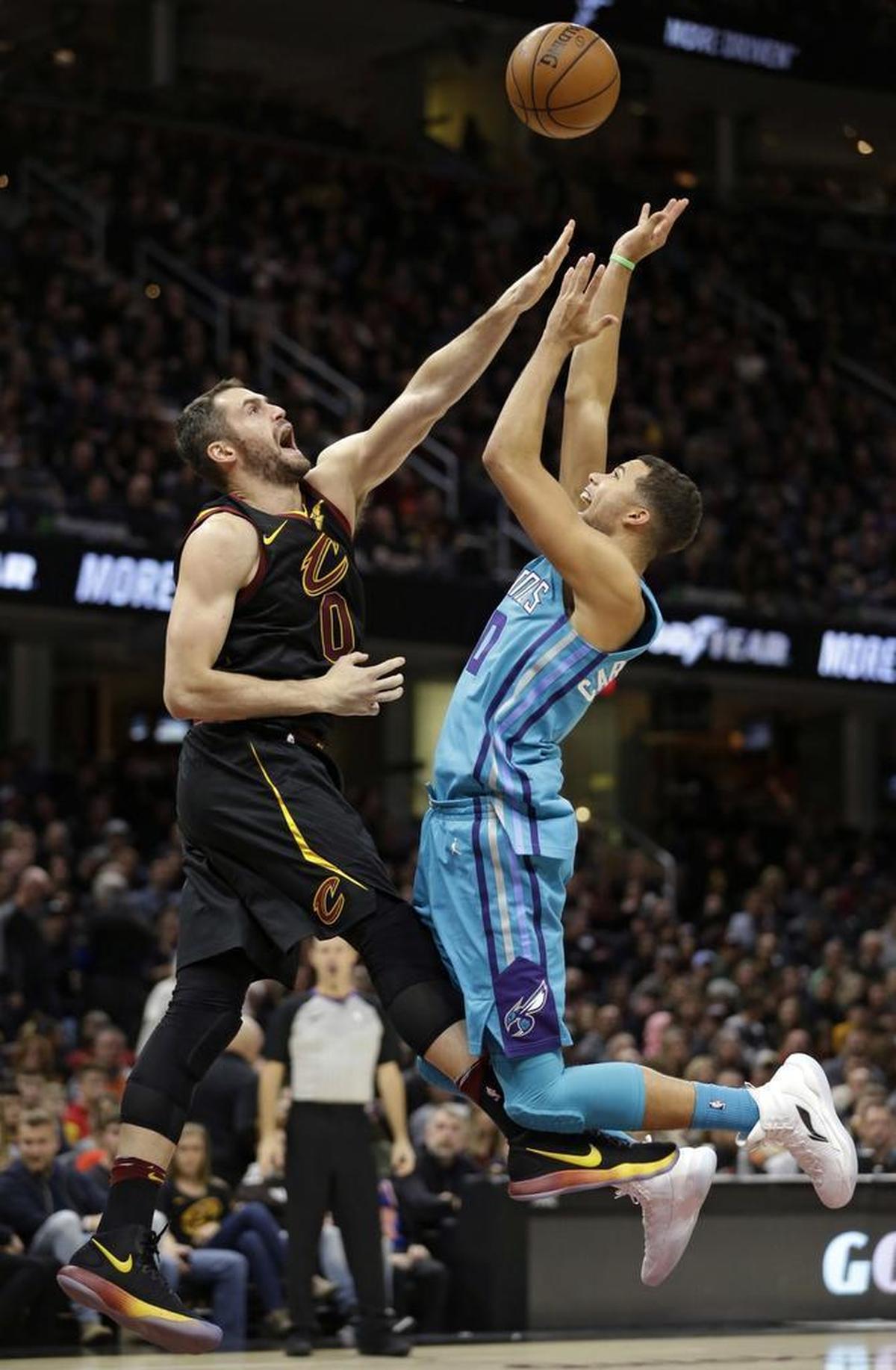 Charlotte Hornets guard Michael Carter-Williams, right, shoots over Cleveland Cavaliers' Kevin Love in the second half of Friday’s game in Cleveland.