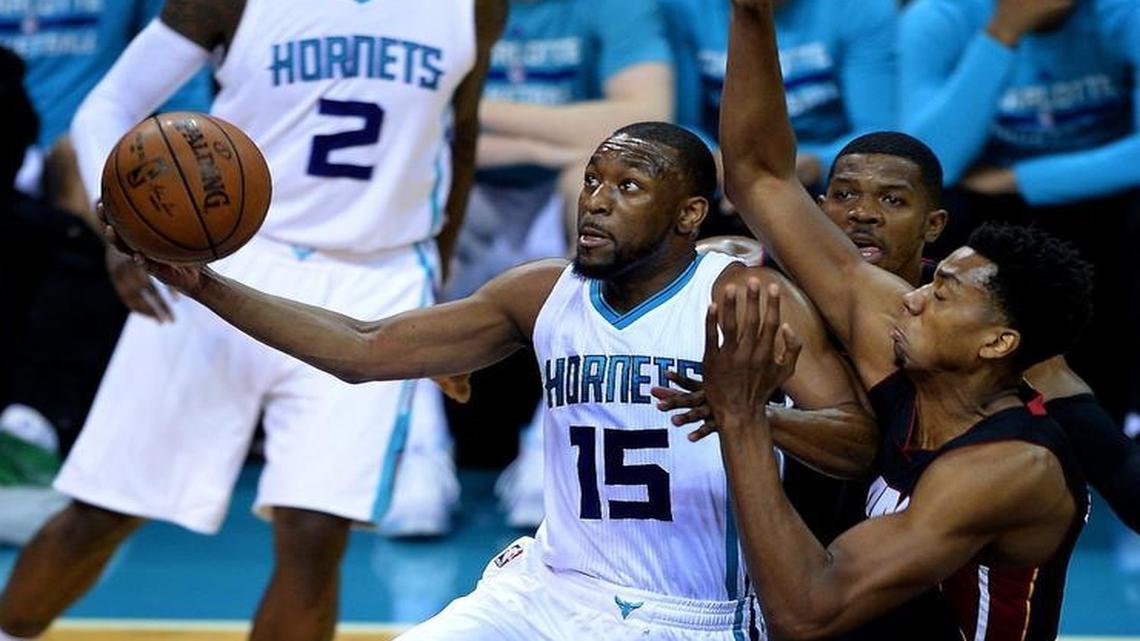 Charlotte Hornets guard Kemba Walker, left, drives to the basket for two points as Miami Heat center Hassan Whiteside, right, attempts to make the stop during Friday’s Game 6 on the teams’ playoff series. .