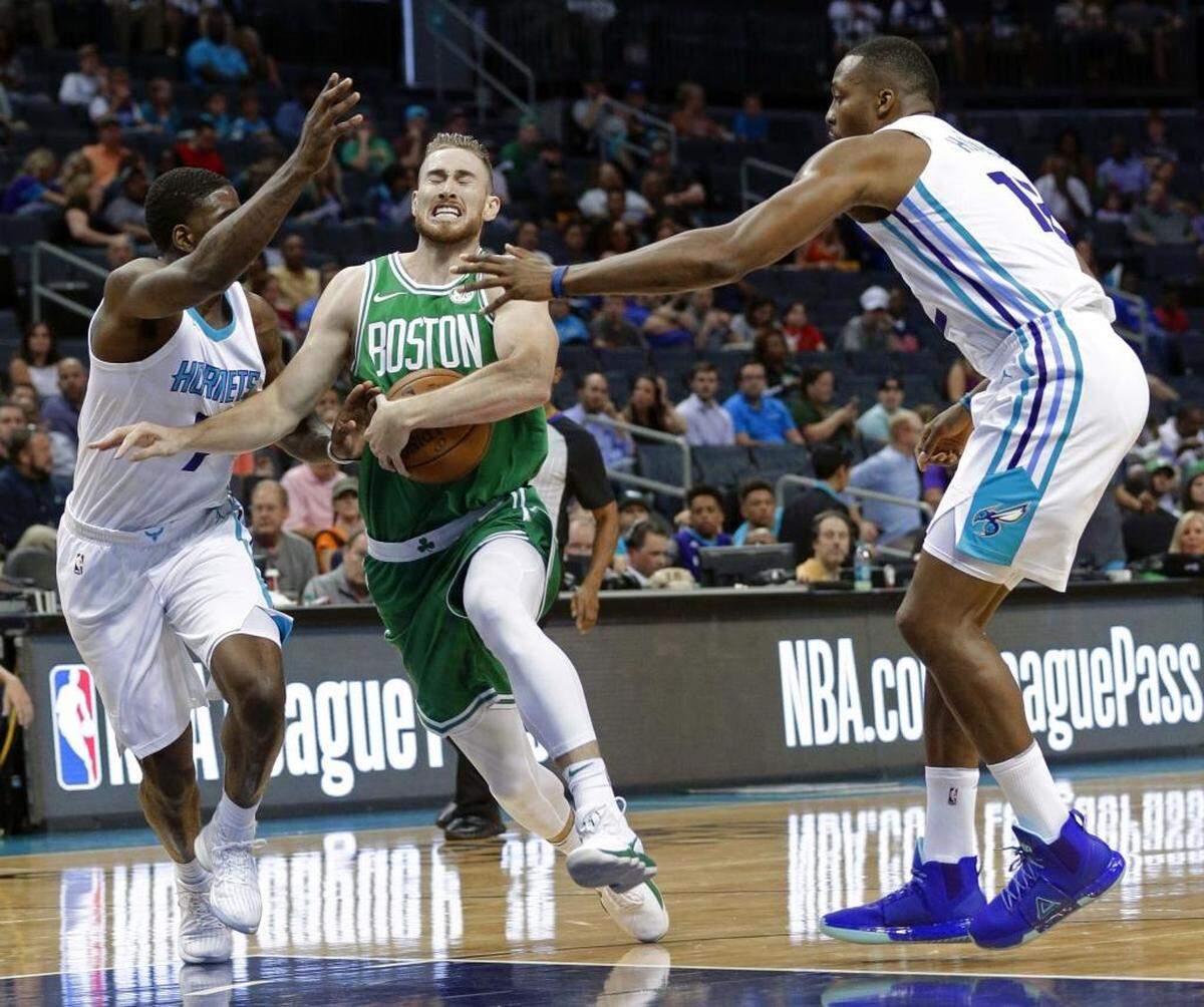 Boston Celtics forward Gordon Hayward, center, is fouled as he drives between Charlotte Hornets center Dwight Howard, right, and rookie Dwayne Bacon, left, in the first half of Wednesday’s preseason game. Bacon finished with 12 points and made all four of his 3-point attempts.