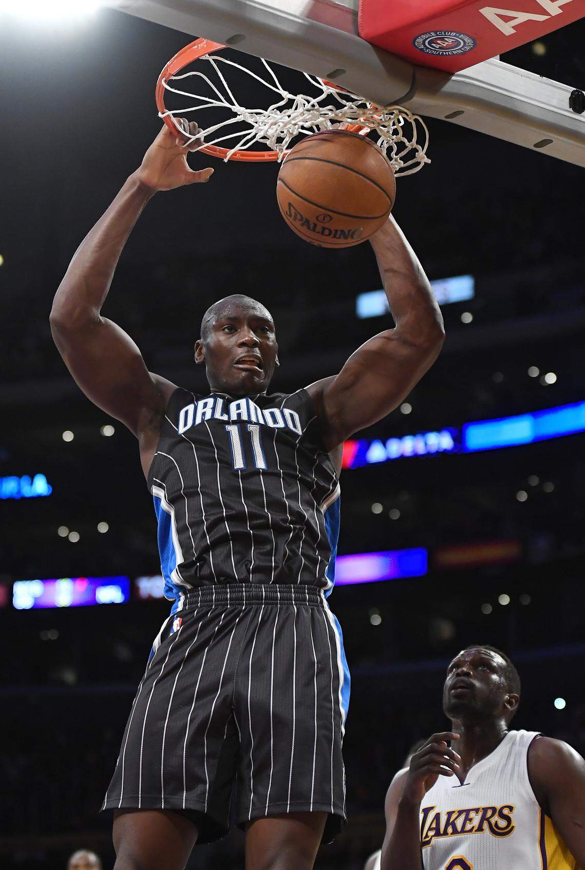 Orlando Magic center Bismack Biyombo, left, of the Republic of Congo dunks as Los Angeles Lakers forward Luol Deng of South Sudan defends during the first half of an NBA basketball game on Jan. 8, 2017, in Los Angeles. (AP Photo/Mark J. Terrill)