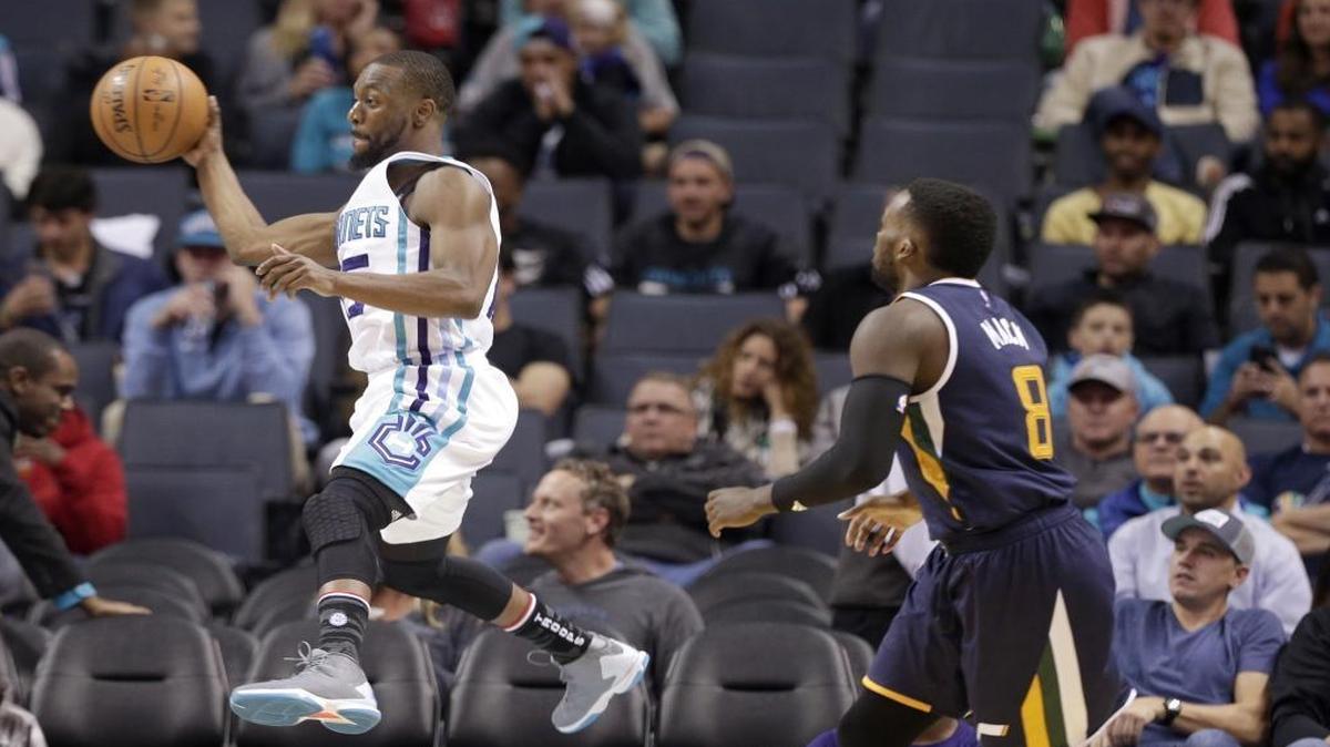 Charlotte Hornets' Kemba Walker, left, saves the ball as Utah Jazz's Shelvin Mack, right, watches during the second half of Wednesday’s game in Charlotte. The Hornets won 104-98 to run their record to 6-1, tied for the NBA’s best.
