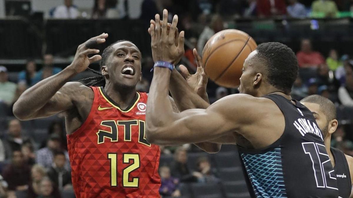 The Atlanta Hawks’ Taurean Prince, left, is fouled as he drives against the Charlotte Hornets’ Dwight Howard during the first half of Friday’s game at Spectrum Center.