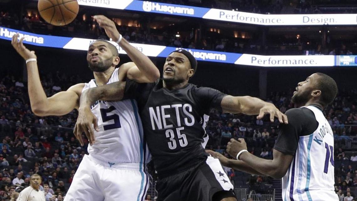 Charlotte’s Nicolas Batum, left, and Michael Kidd-Gilchrist, right, battle Brooklyn Nets center Trevor Booker for a rebound during the second half of Tuesday night’s game in Charlotte. The Hornets won 111-107.
