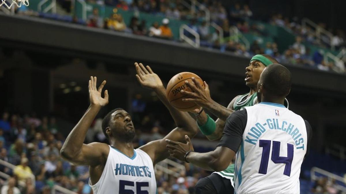 Boston Celtics guard Isaiah Thomas takes a shot between Charlotte Hornets center Roy Hibbert (55) and forward Michael Kidd-Gilchrist (14) in the first quarter of Thursday’s preseason game in Greensboro.