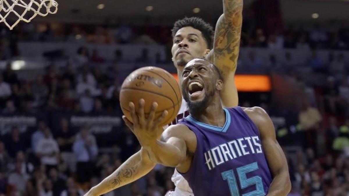 Charlotte Hornets guard Kemba Walker (15) goes to the basket as Miami Heat guard Gerald Green (14) defends in the first half of Wednesday’s season opener at Miami.
