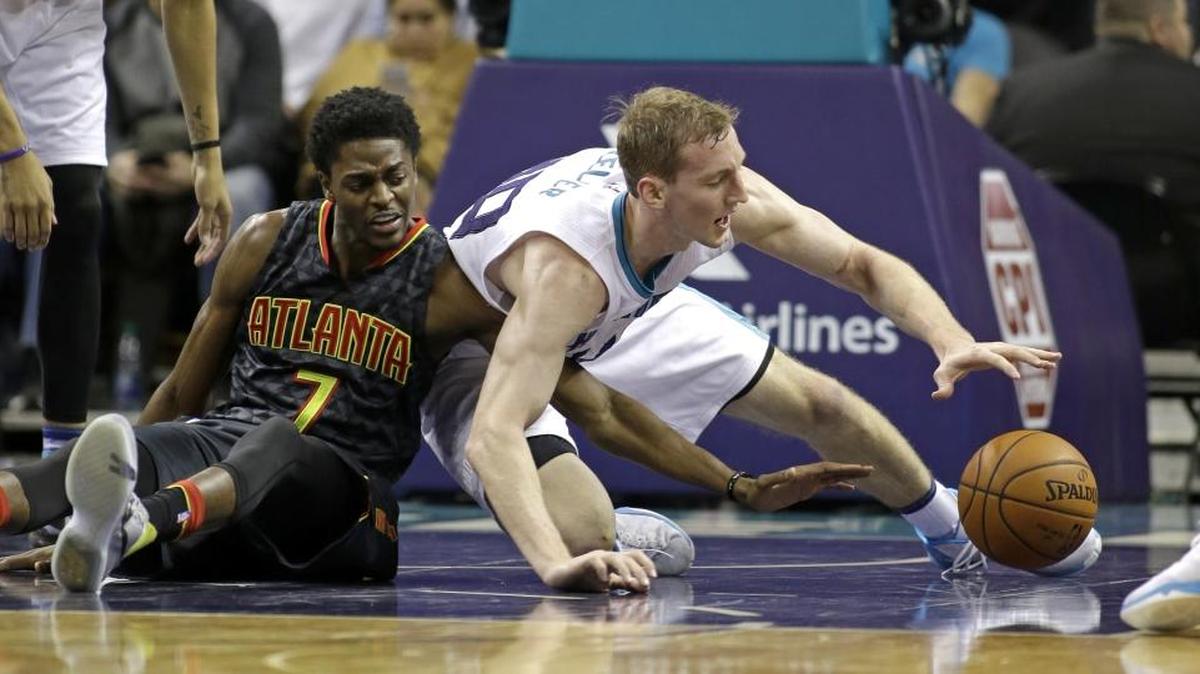 Atlanta Hawks' Justin Holiday (7) and Charlotte Hornets' Cody Zeller (40) battle for a loose ball in Wednesday’s game in Charlotte.