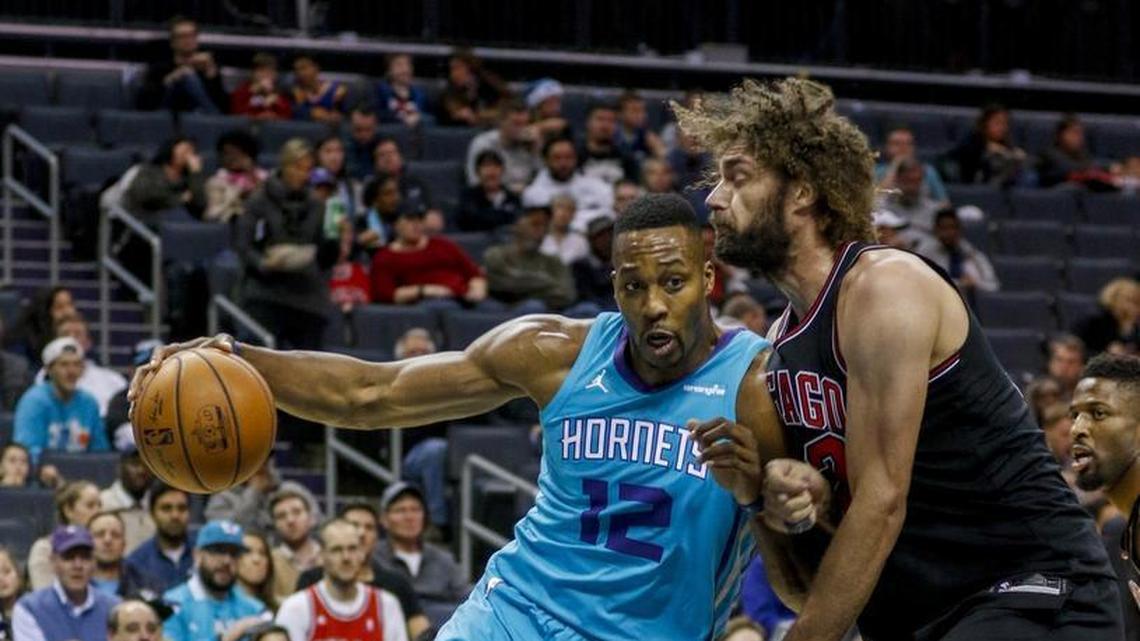 Charlotte Hornets center Dwight Howard, left, drives into Chicago Bulls center Robin Lopez in the first half of Friday’s game at Spectrum Center.
