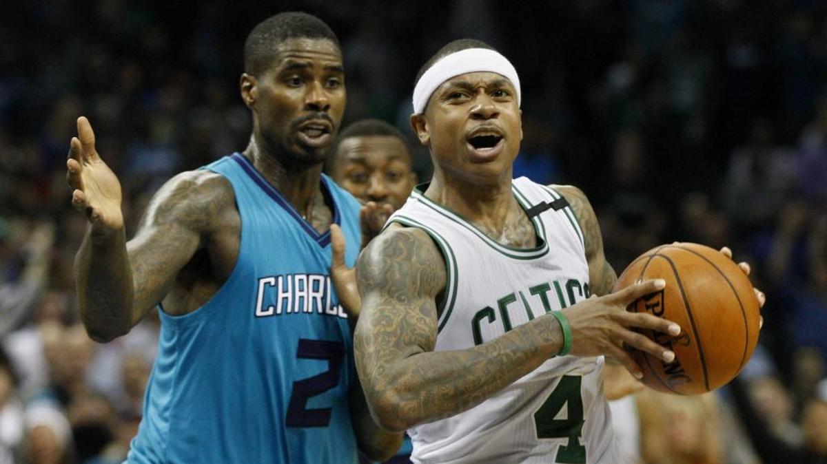Boston Celtics guard Isaiah Thomas, right, protects the ball from Charlotte Hornets forward Marvin Williams in the second half of Saturday’s game. Boston won 98-93.