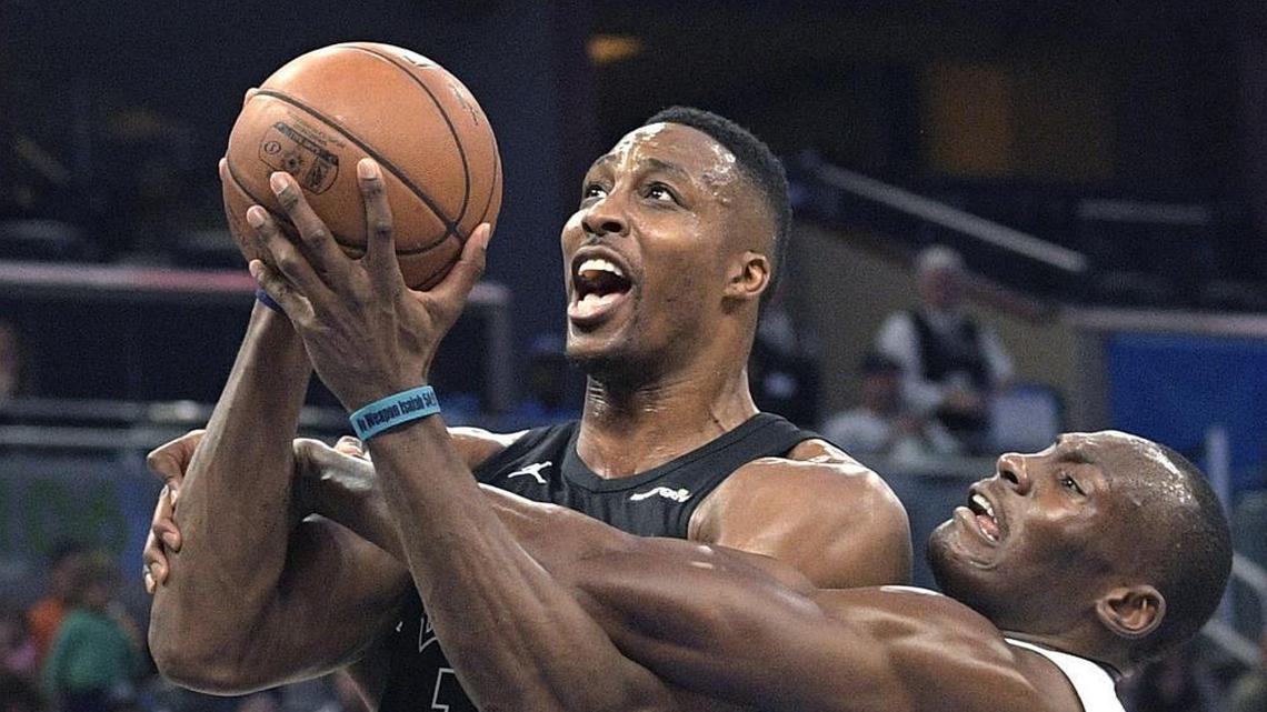 Charlotte Hornets center Dwight Howard (12) is fouled by Orlando Magic center Bismack Biyombo, right, while going up for a shot during the first half of Wednesday’s game.