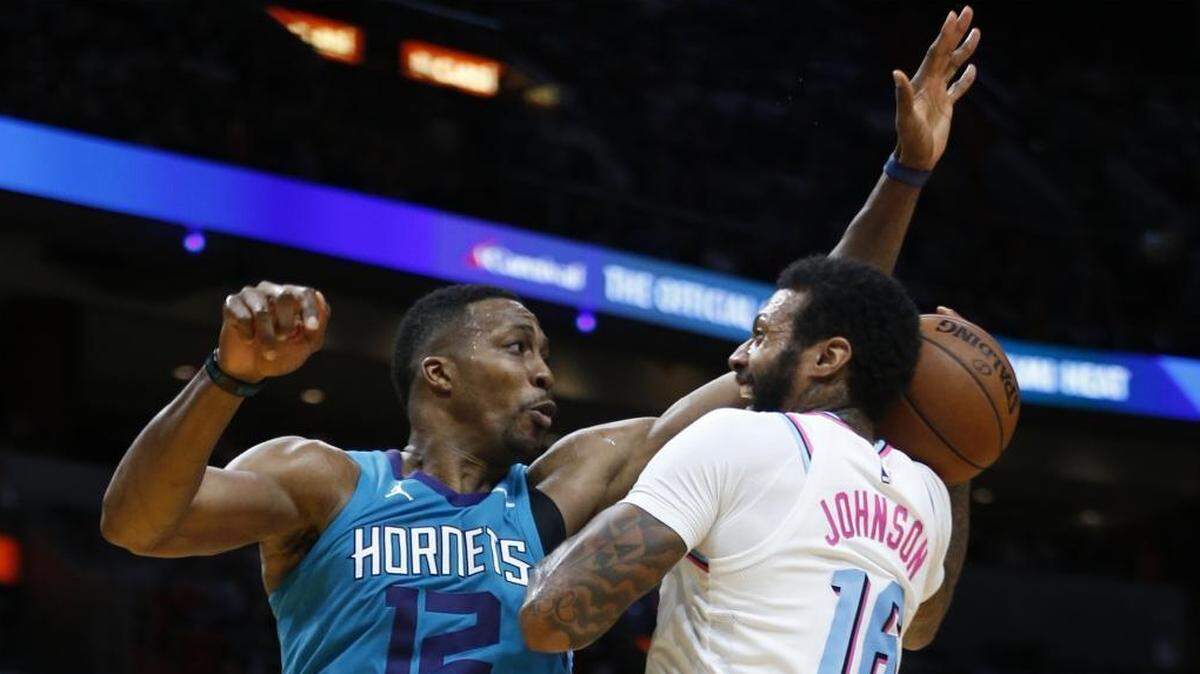 Miami Heat forward James Johnson (16) goes up to shoot against Charlotte Hornets center Dwight Howard (12) during the second half of Saturday’s game. Miami won, 95-91.