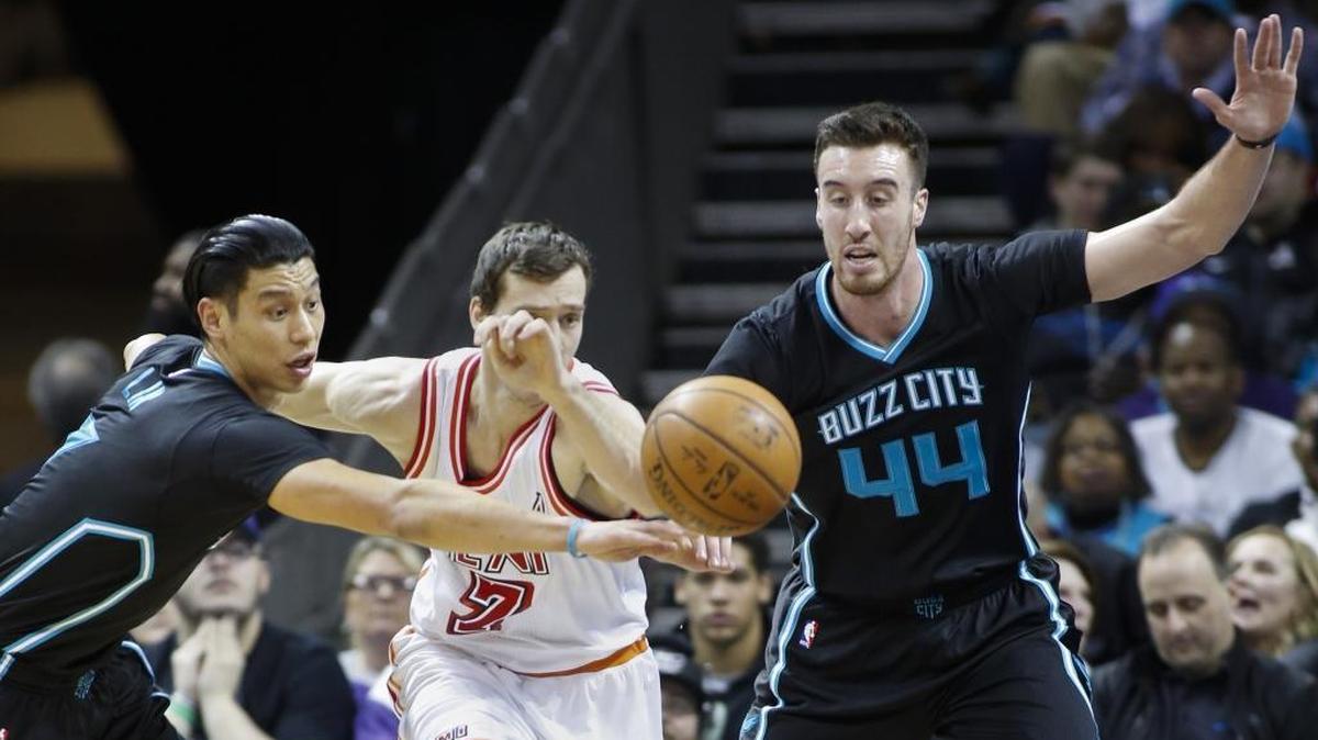 Charlotte Hornets guard Jeremy Lin, left, and center Frank Kaminsky, right, battle Miami Heat guard Goran Dragic for a loose ball in the first half of an NBA basketball game Friday in Charlotte.