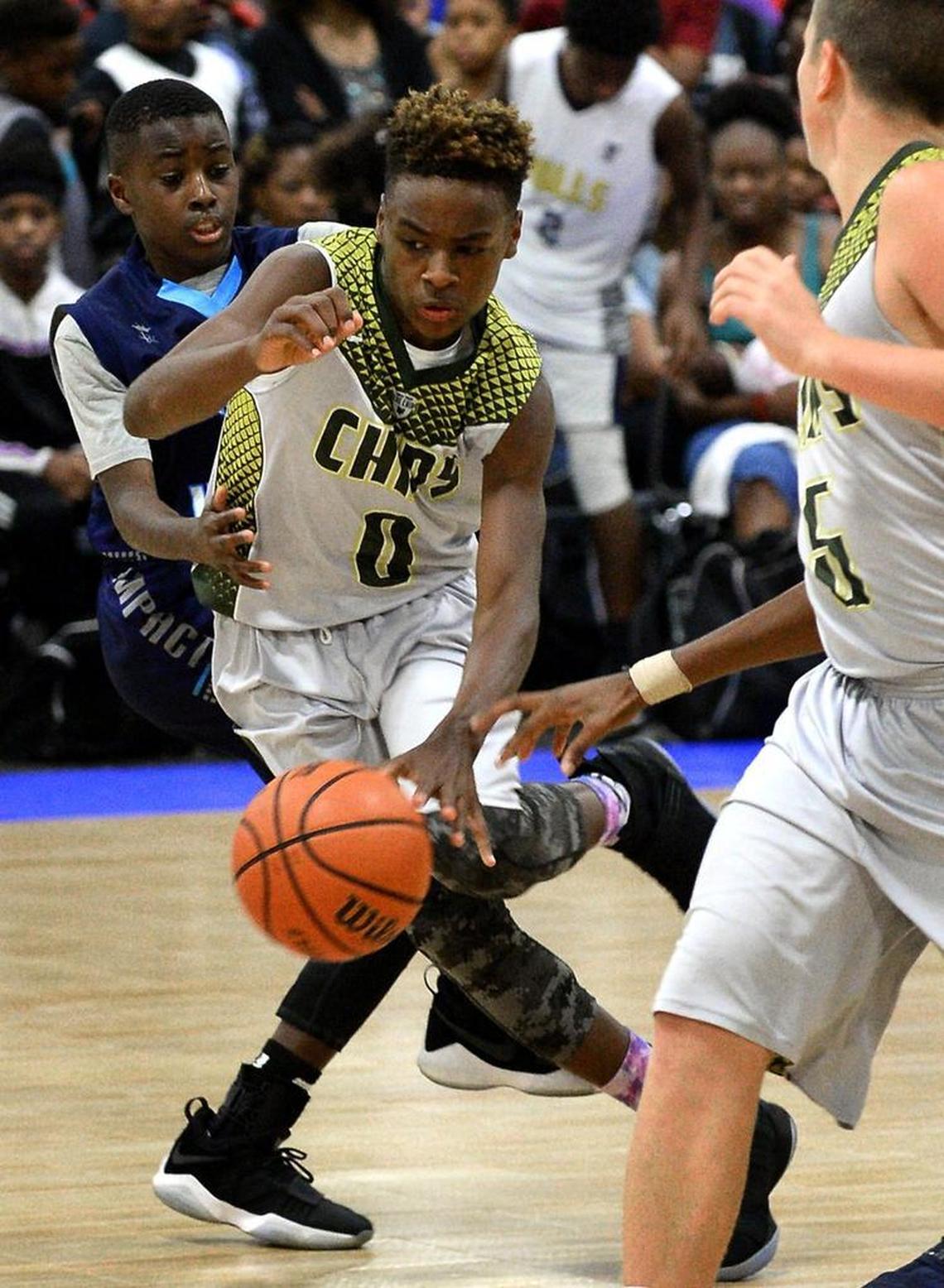 LeBron James Jr., center, tries to maintain control of the ball as he dribbles downcourt at the Charlotte Convention Center on Friday. LeBron Jr. and his North Coast Blue Chips (Ohio) teammates are in Charlotte for the United States Basketball Association National Tournament.