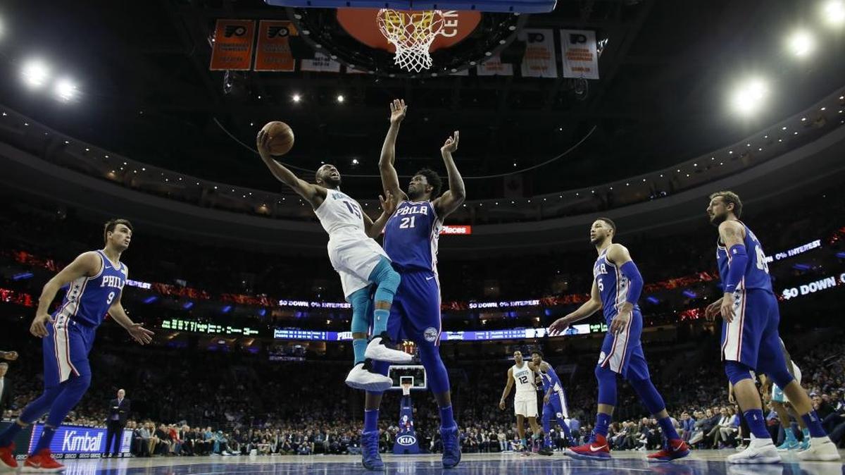 Charlotte Hornets’ Kemba Walker, left, goes up for a shot against Philadelphia 76ers’ Joel Embiid during the second half of an NBA basketball game, Monday, March 19, 2018, in Philadelphia. Philadelphia won 108-94.