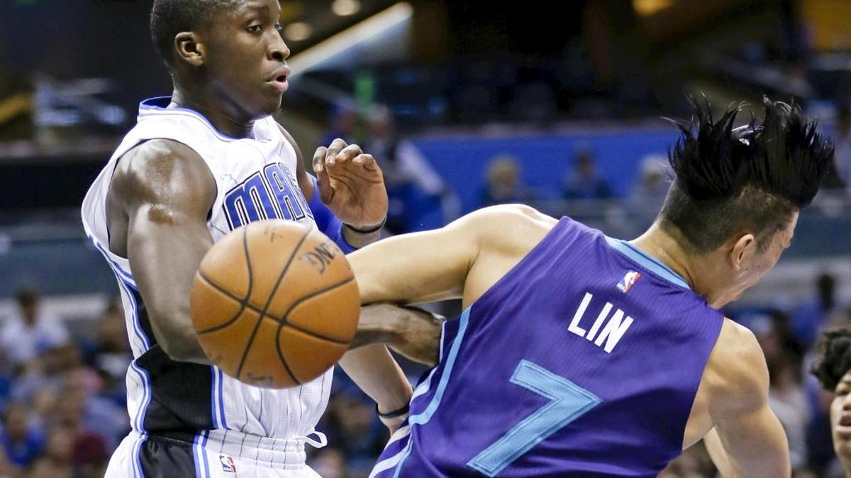 Charlotte Hornets guard Jeremy Lin (7) loses the ball as he collides with Orlando Magic guard Victor Oladipo, left, during the first half of an NBA basketball game Wednesday, Dec. 16, 2015, in Orlando, Fla.