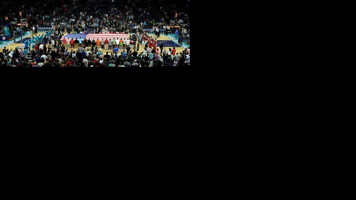 
Fans and players listen to the National Anthem prior to the Charlotte Hornets - Atlanta Hawks game at Time Warner Cable Arena in Charlotte, Saturday, March 28, 2015. The Hornets defeated the Hawks 115-100.
