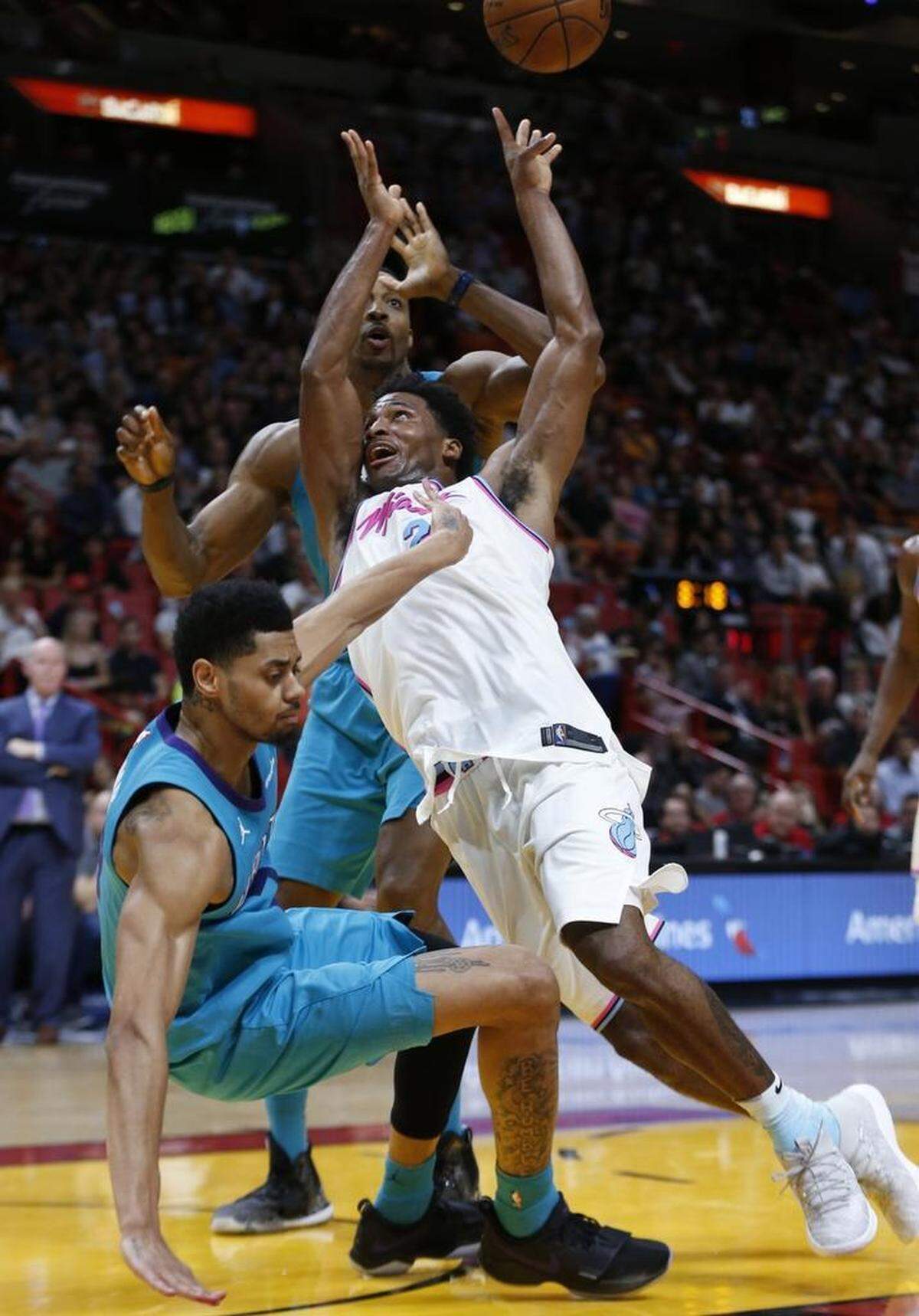 Miami Heat forward Justise Winslow, center, loses control of the ball as he drives to the basket against Charlotte Hornets guard Jeremy Lamb, left, and center Dwight Howard, rear, during the second half of Saturday’s game.