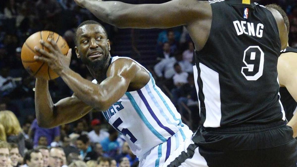 Charlotte Hornets guard Kemba Walker, left, attempts to pass the ball around Miami Heat forward Luol Deng during Wednesday night's game at Time Warner Cable Arena. The Charlotte Hornets defeated the Miami Heat 99-81.