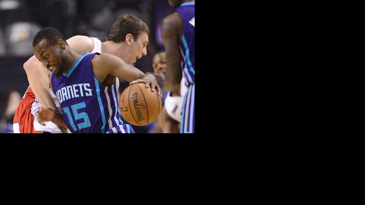 
Toronto Raptors' Tyler Hansbrough defends as Charlotte Hornets' Kemba Walker drives around him,  Wednesday, April 15, 2015, in Toronto. 

