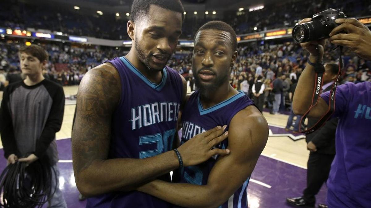 Charlotte Hornets guard Troy Daniels, left, is hugged by teammate Kemba Walker after scoring the winning basket against the Sacramento Kings in an NBA basketball game Jan. 25, 2016, in Sacramento, Calif.
