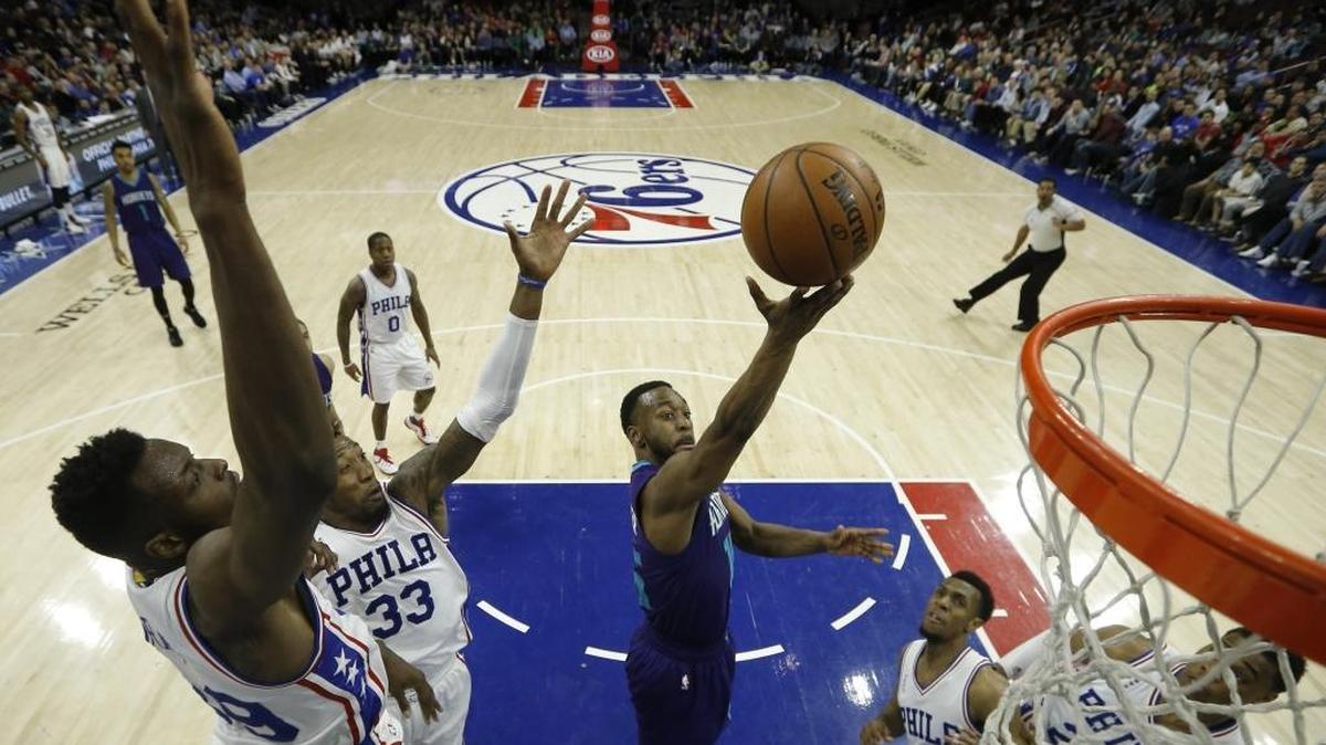 Charlotte Hornets' Kemba Walker, center, goes up for a shot between Philadelphia 76ers' Jerami Grant, from left, Robert Covington, Ish Smith and Richaun Holmes during the second half of Wednesday’s game. Charlotte won 119-99.