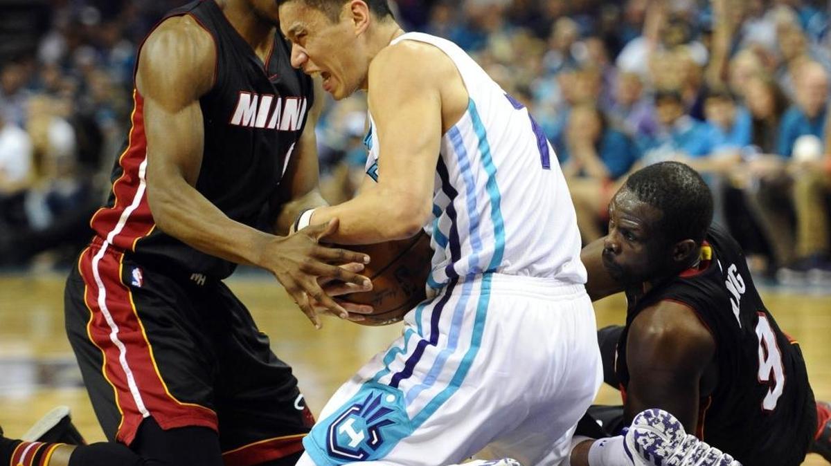 Charlotte Hornets guard Jeremy Lin (7) clutches the ball away from Miami Heat guard Josh Richardson (0) and forward Luol Deng (9) in the first half of Game 4 of the Eastern Conference playoffs' first round on Monday, April 25, 2016.