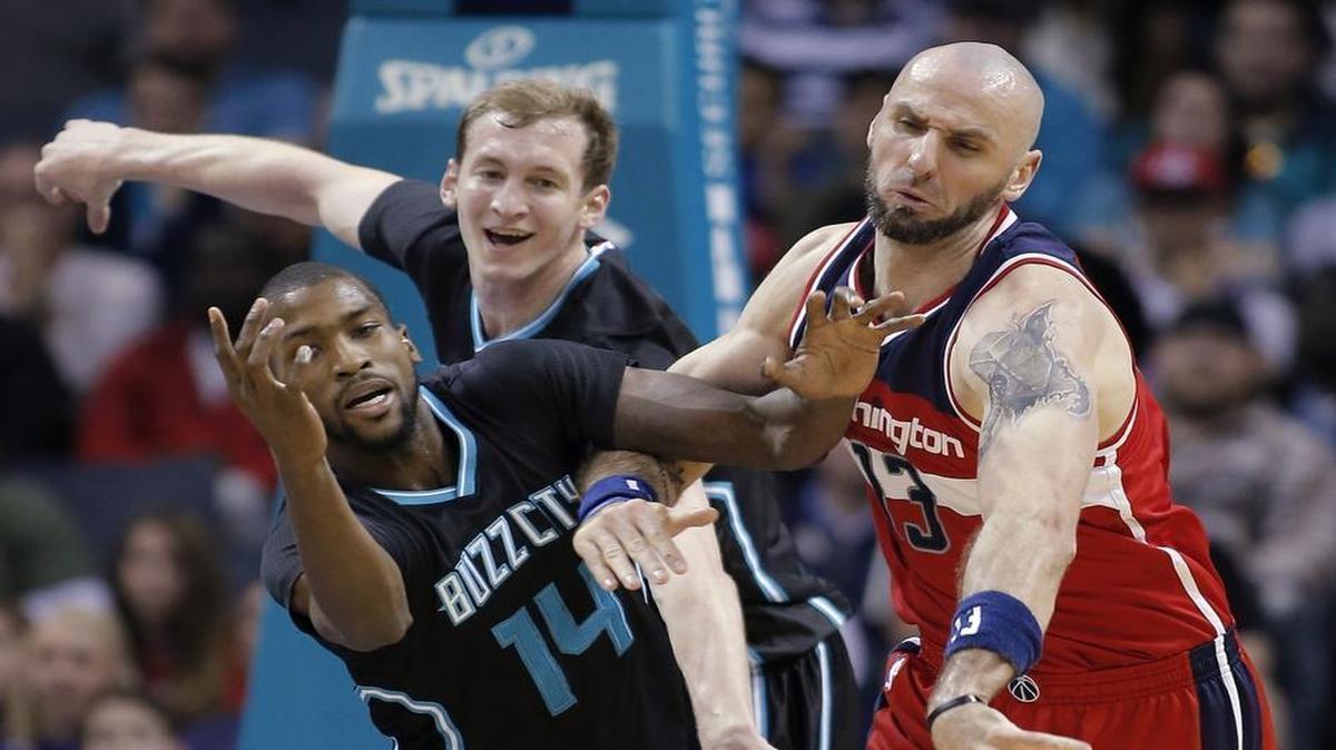 Charlotte Hornets Michael Kidd-Gilchrist, left, and Cody Zeller, middle, vie for a loose ball with the Washington Wizards' Marcin Gortat during the first half of Saturday’s game.