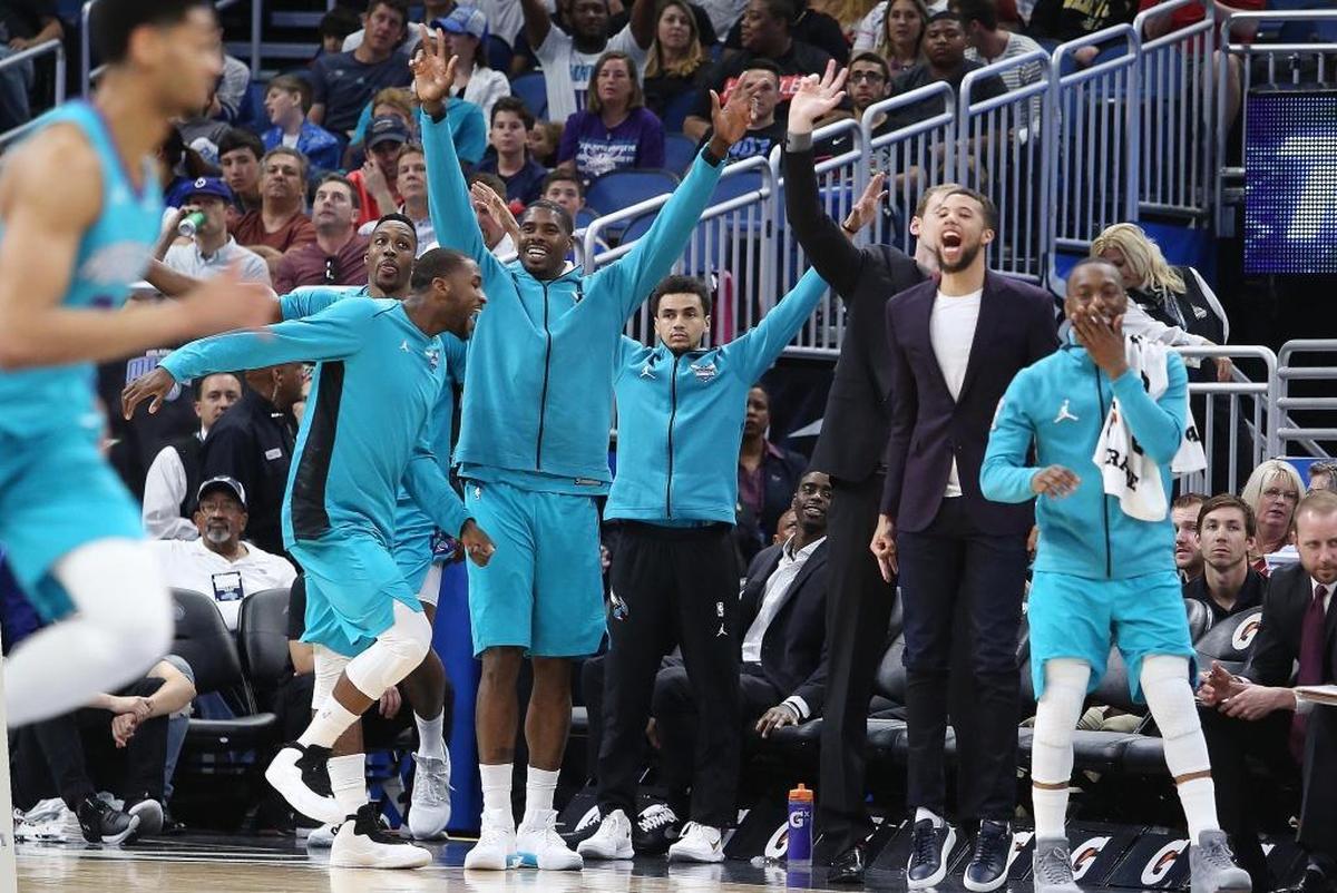 The Charlotte Hornets bench celebrates during the first half of Friday’s game at Orlando. The Hornets routed the Magic, 137-100.