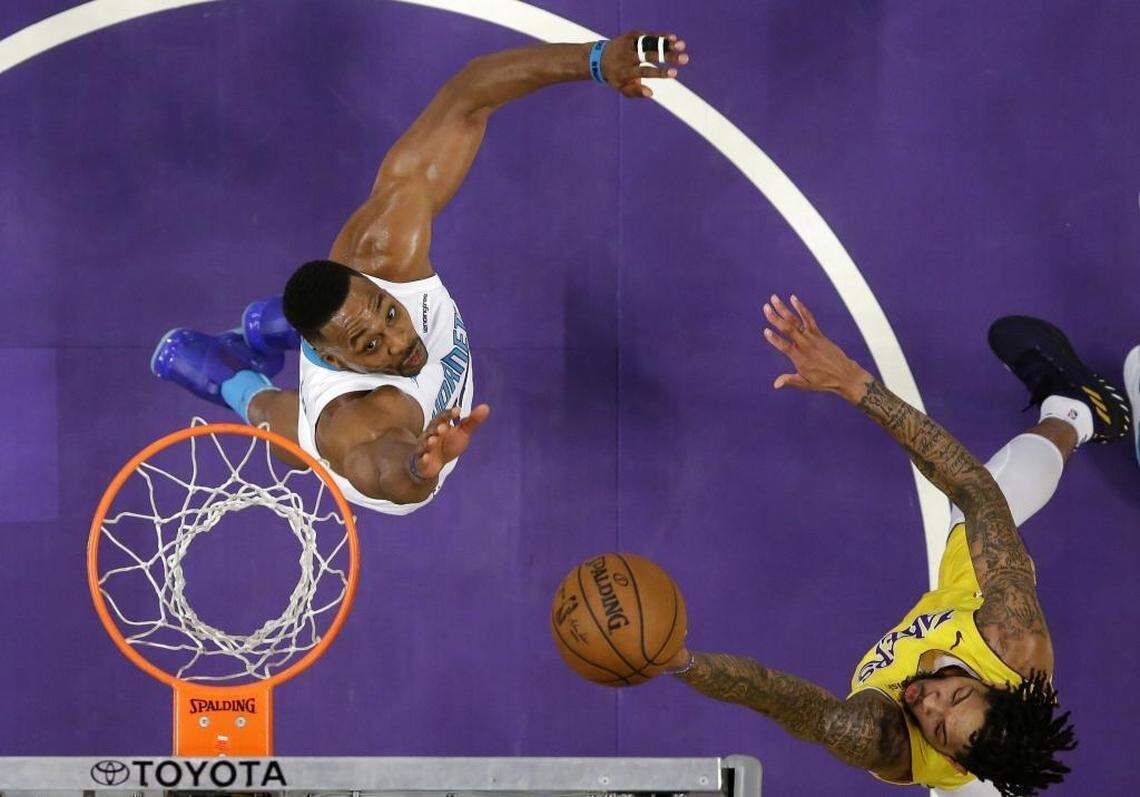 Los Angeles Lakers forward Brandon Ingram, right, shoots as Charlotte Hornets center Dwight Howard defends during the first half of Friday’s game.