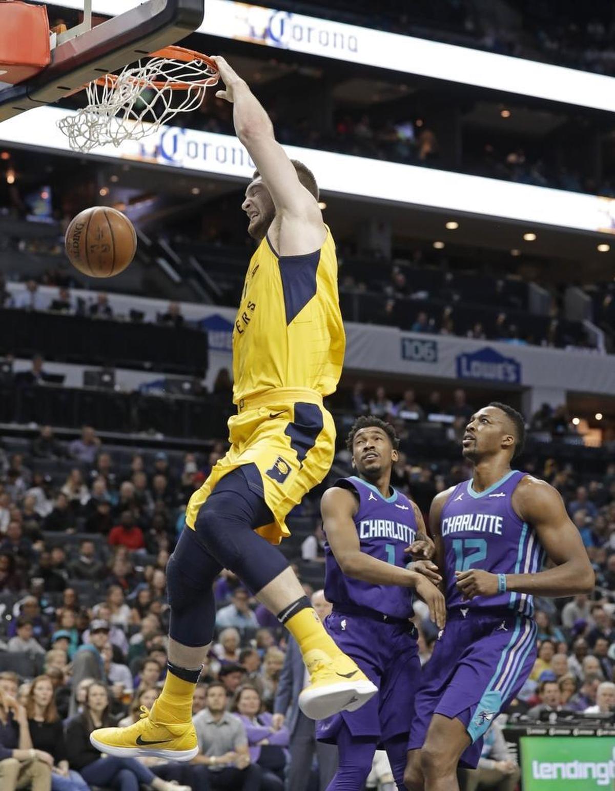 Indiana Pacers big man Domantas Sabonis came off the bench to score a career-high 30 points in Sunday’s 123-117 win over the host Charlotte Hornets. Above, Sabonis (11) dunks past Charlotte Hornets center Dwight Howard (12) and Malik Monk (1).