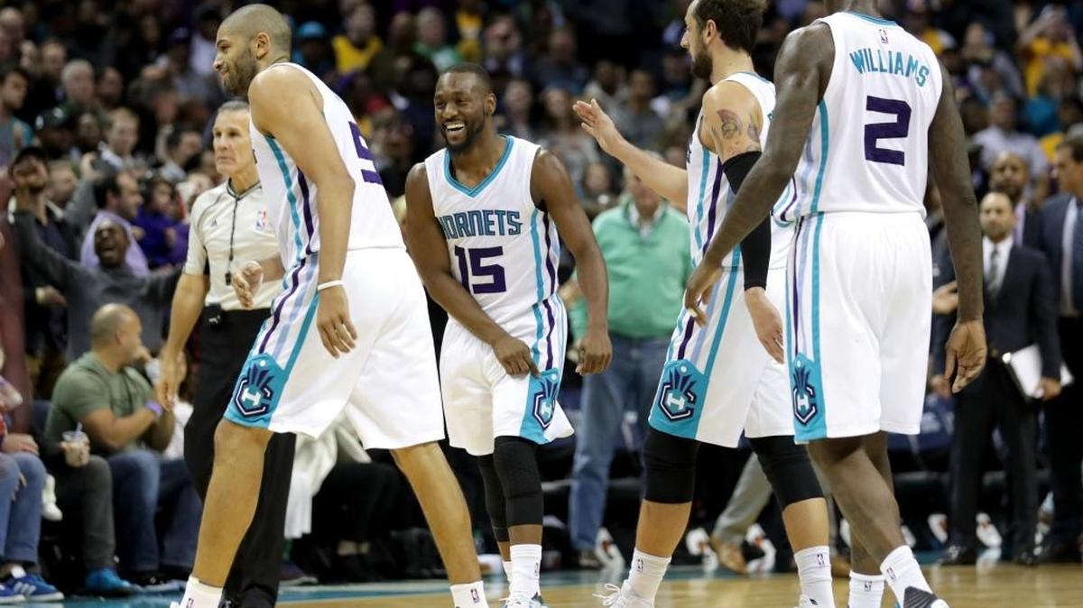 Charlotte’s Nic Batum (left) and Kemba Walker (15) smile after Batum hit the go-ahead basket Tuesday against the Los Angeles Lakers.